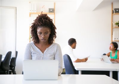Serious excited African American employee working on computer